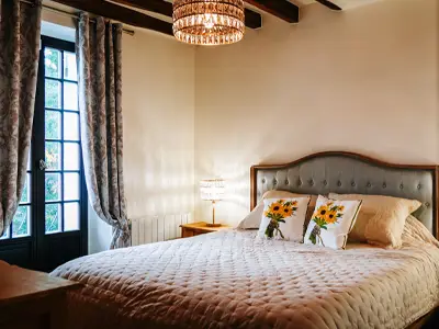 Chambre principale de la Villa Clairemaison avec lit double 180 cm et poutres apparentes