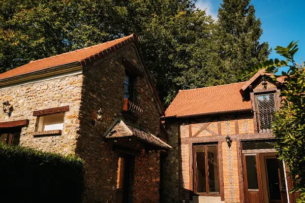 Façade de la Maison d'Amis avec architecture traditionnelle et jardin paysager