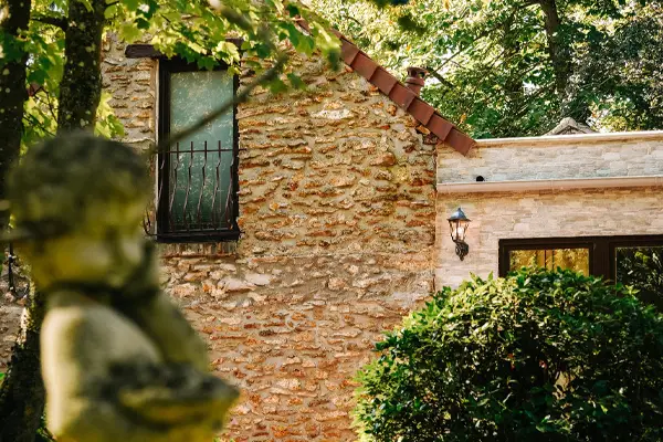 Vue de la Maison d'Amis depuis le parc arboré du domaine