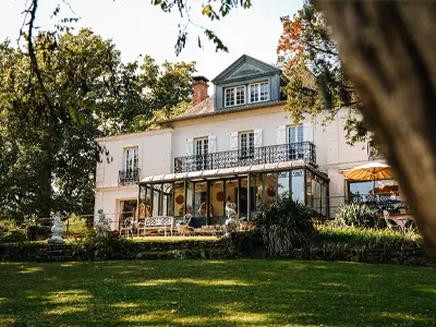 Véranda du manoir avec vue sur le parc arboré du Domaine Villa Clairemaison